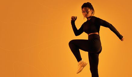 Woman in fitness attire with orange background